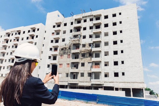 Under-construction apartment building with construction workers